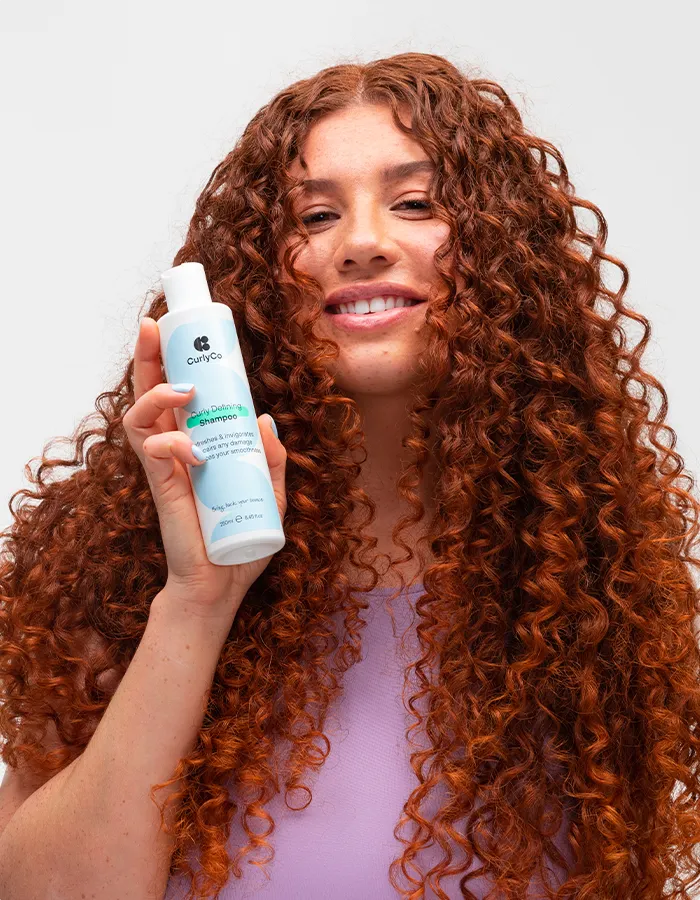 Woman holding Curly Co shampoo
